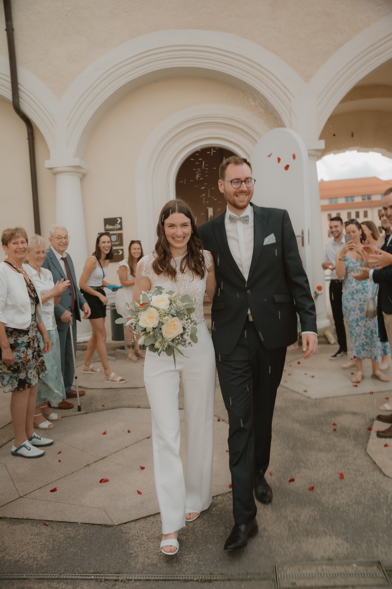 Brautpaar schreitet durch einen Torbogen