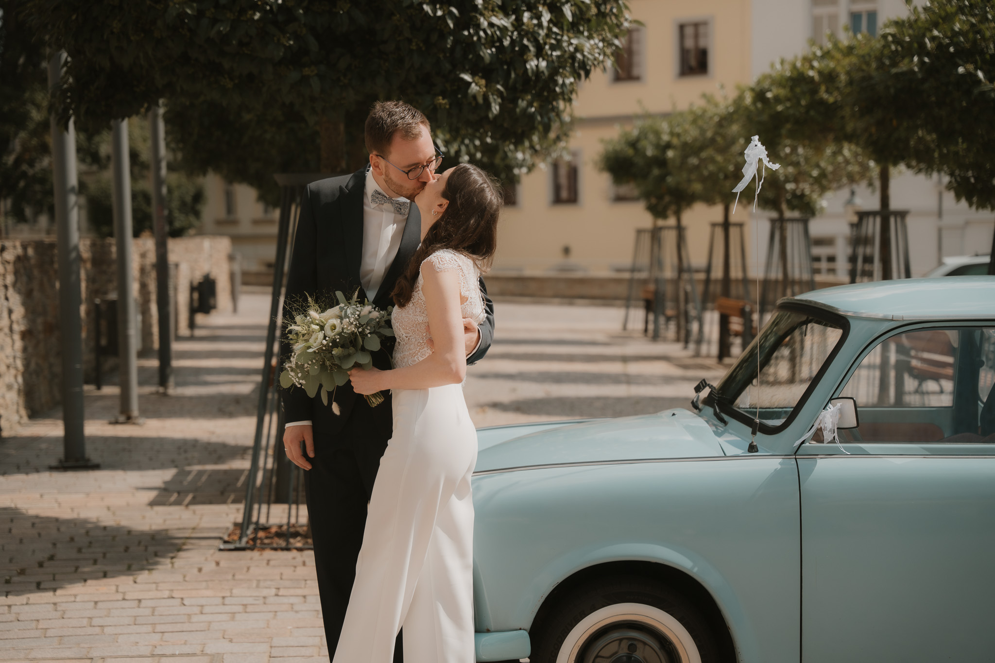 Brautpaar posiert vor dem Oldtimer