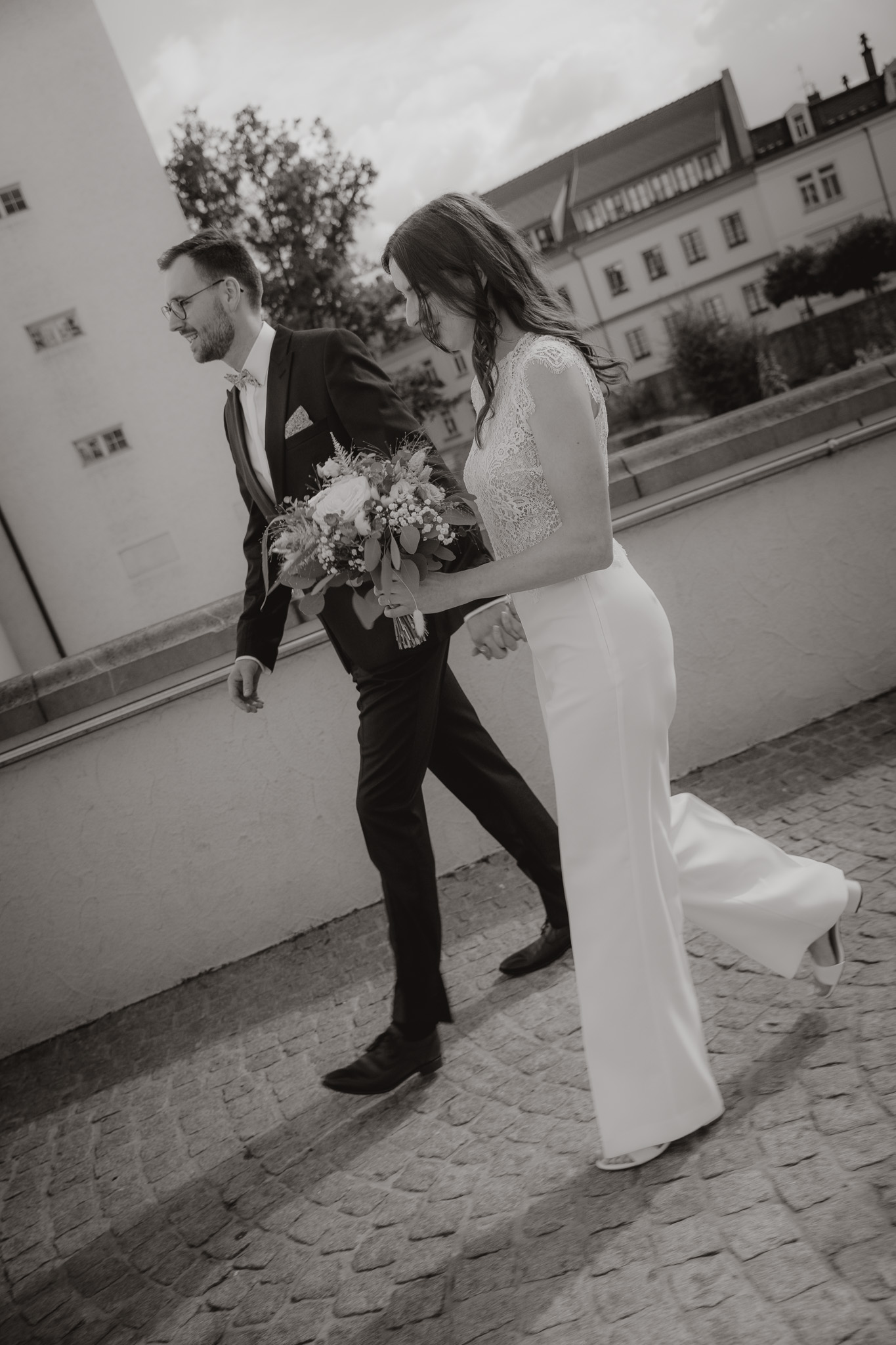 Brautpaar läuft in stilvoller Schwarz-Weiß-Aufnahme